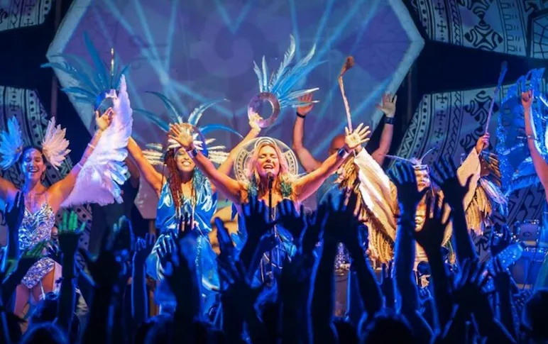 women singing in concert with a lot back dancers