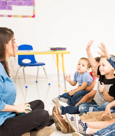 Children Raising Hand to Teacher in Daycare Class
