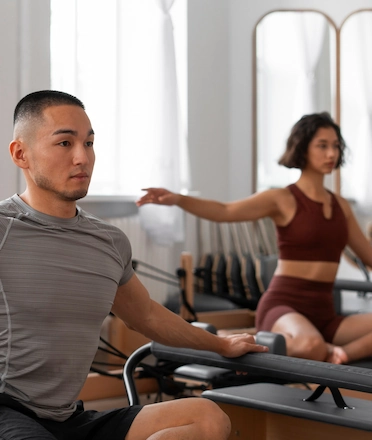Men and Women doing Pilates Reform Class