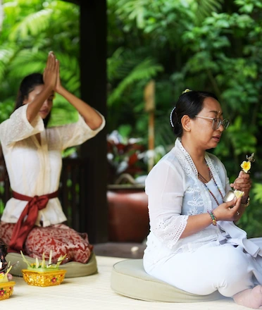 Tourist Praying With Female Mangku in Westin Ubud