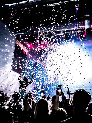 Crowd celebrating at a nightclub during New Year’s Eve as confetti rains down