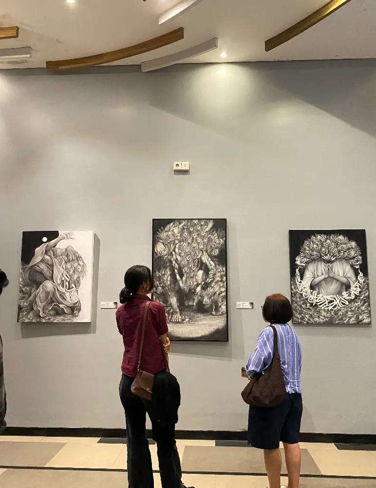 Visitors observe pencil-on-canvas artworks