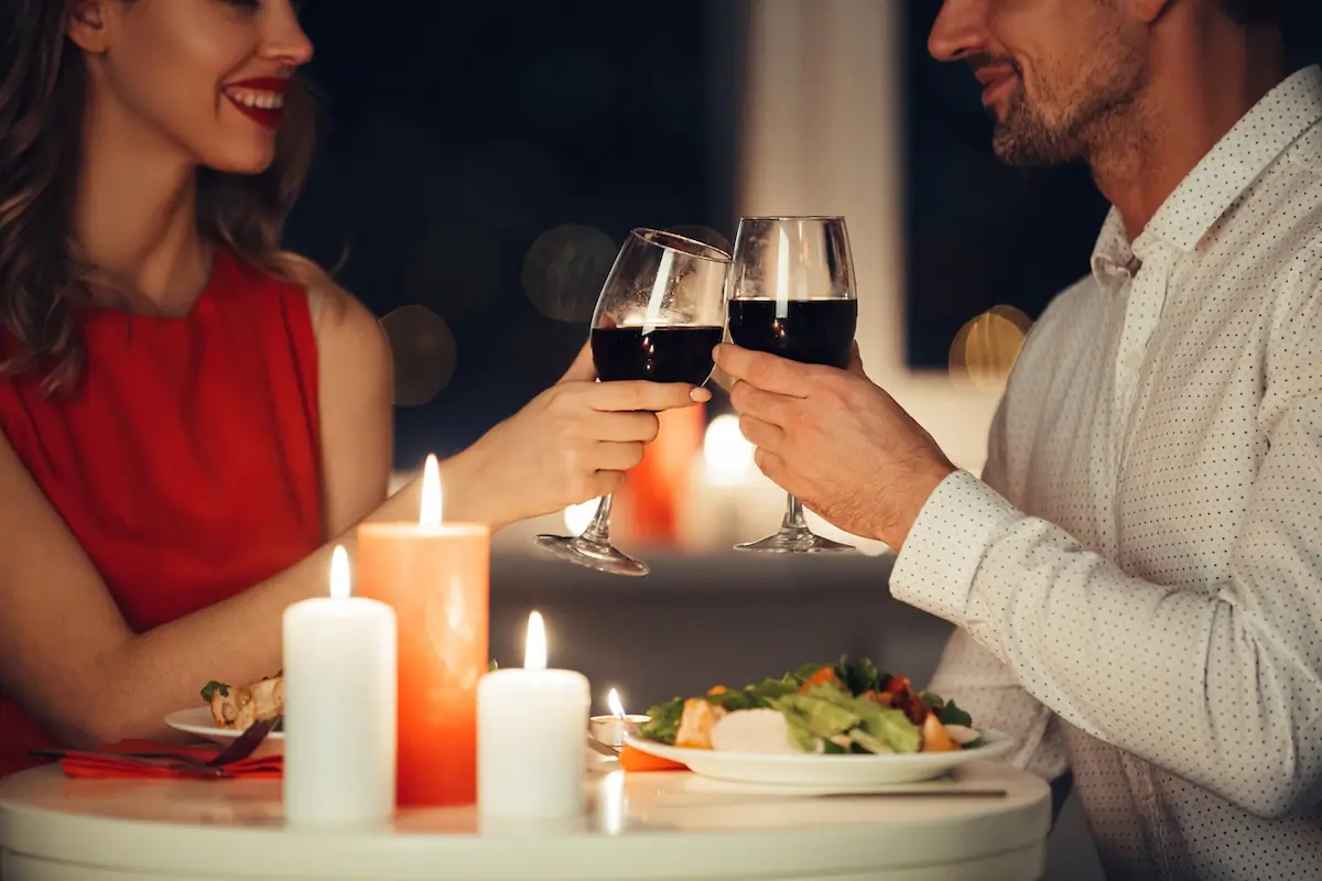a couple enjoying romantic time cheering with wine glasses