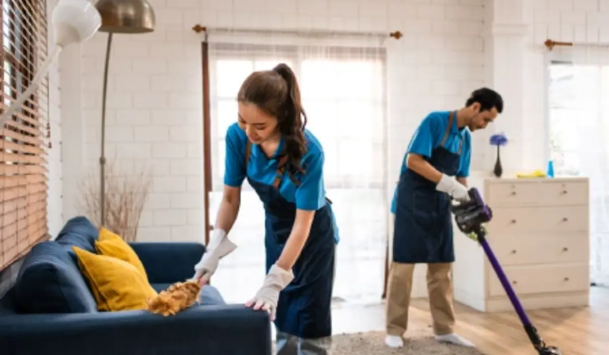 Two professional cleaners tidying a living room