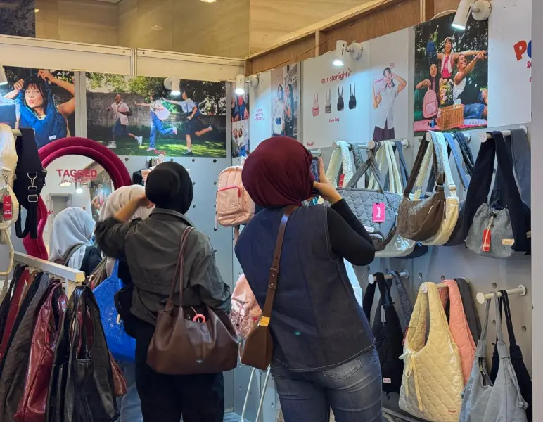Visitors browsing bags at a local fashion brand booth during Trademark Market