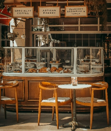 Interior of a café featuring a wooden bakery counter filled with pastries