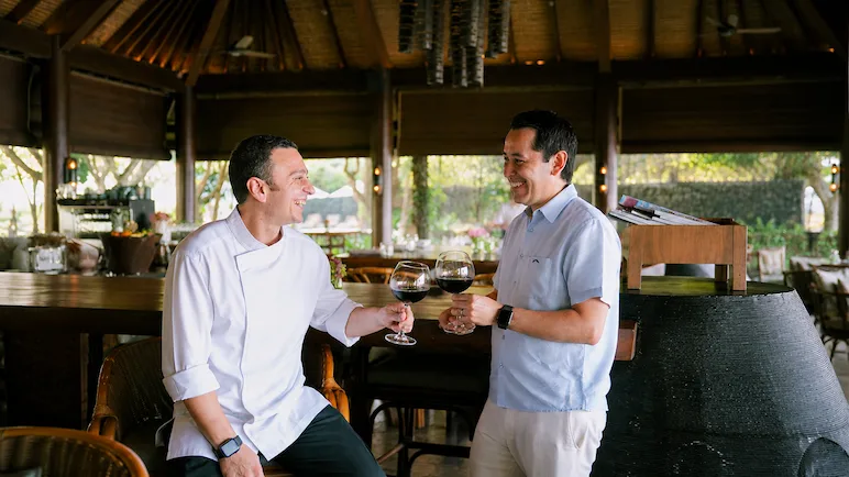 two people holding a glass of wine
