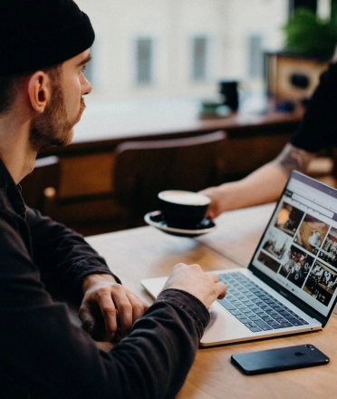 man_working_on_laptop_in_cafe