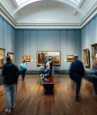 people_looking_at_paintings_in_a_museum