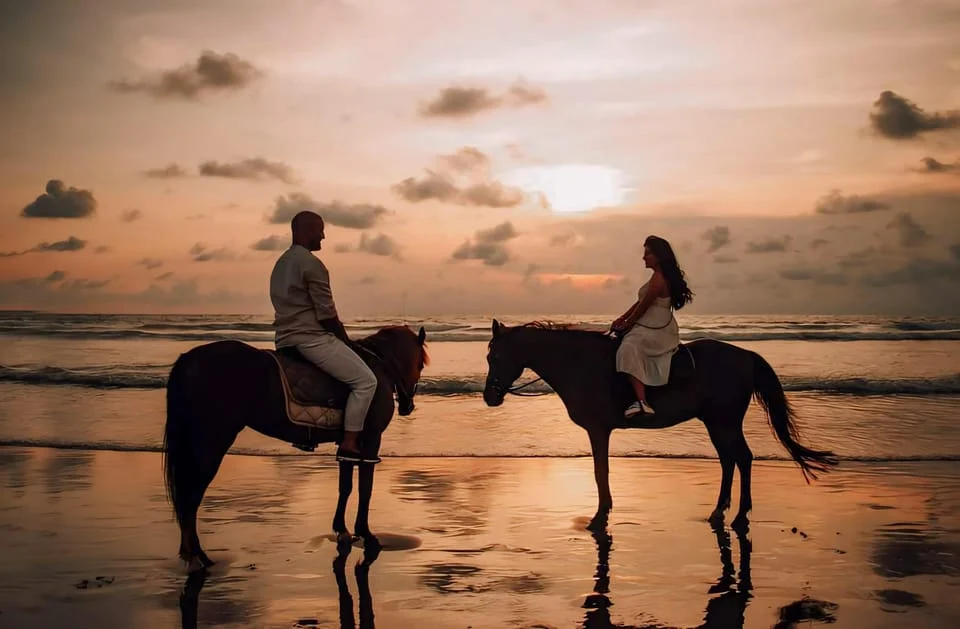 a couple horseding sunset 