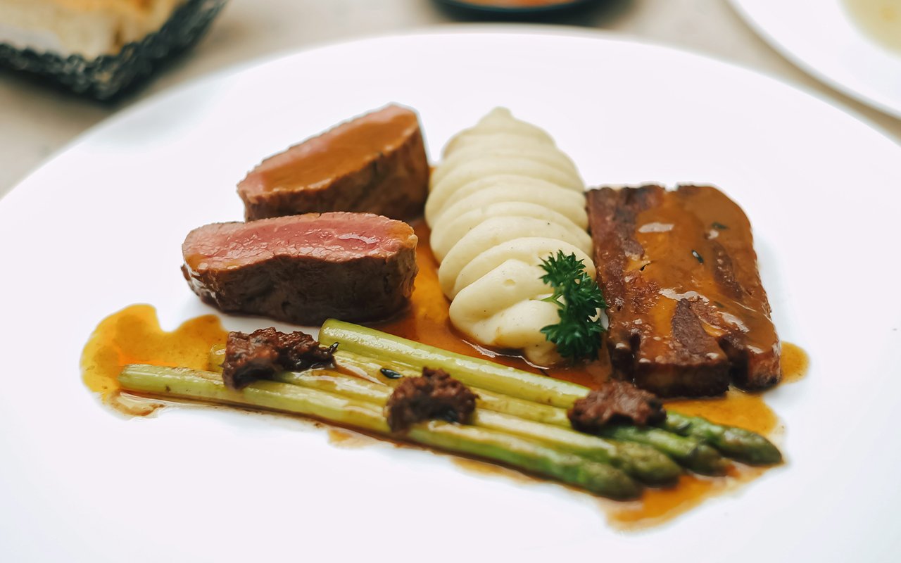 Pancia di agnello croccante, filetto, asparagi e pesto rosso