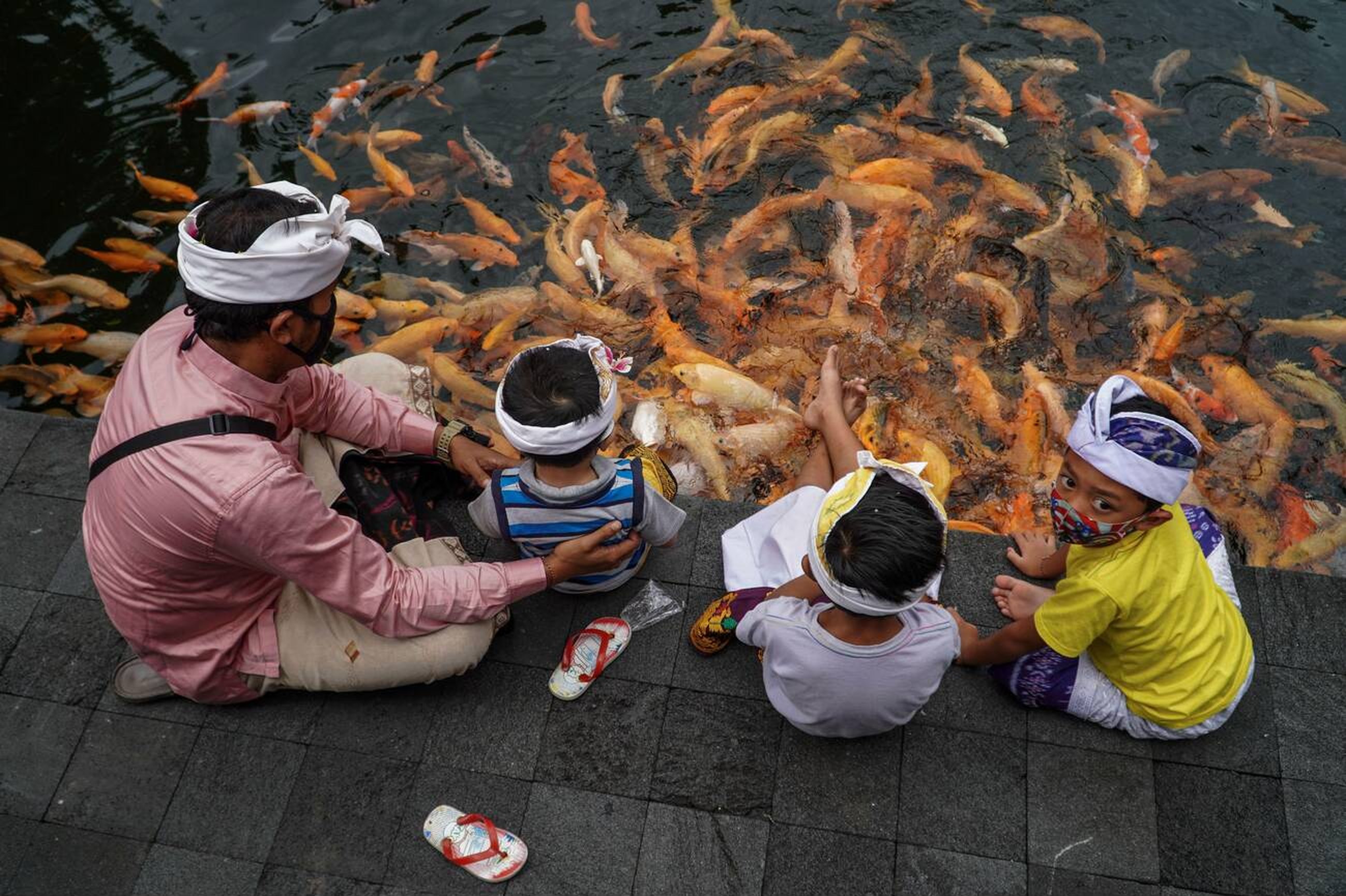 Children Playing at Temple's Fish Pond in Between the Banyu Pinaruh Ceremony